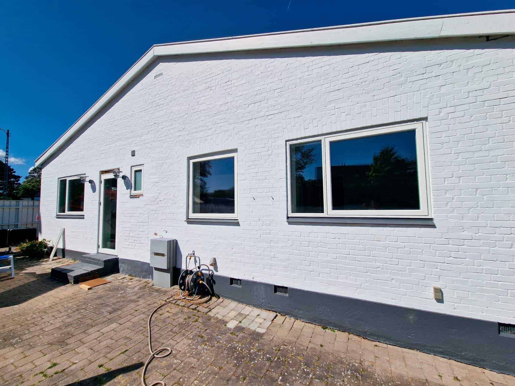 Hvidt murstenshus med nye vinduer